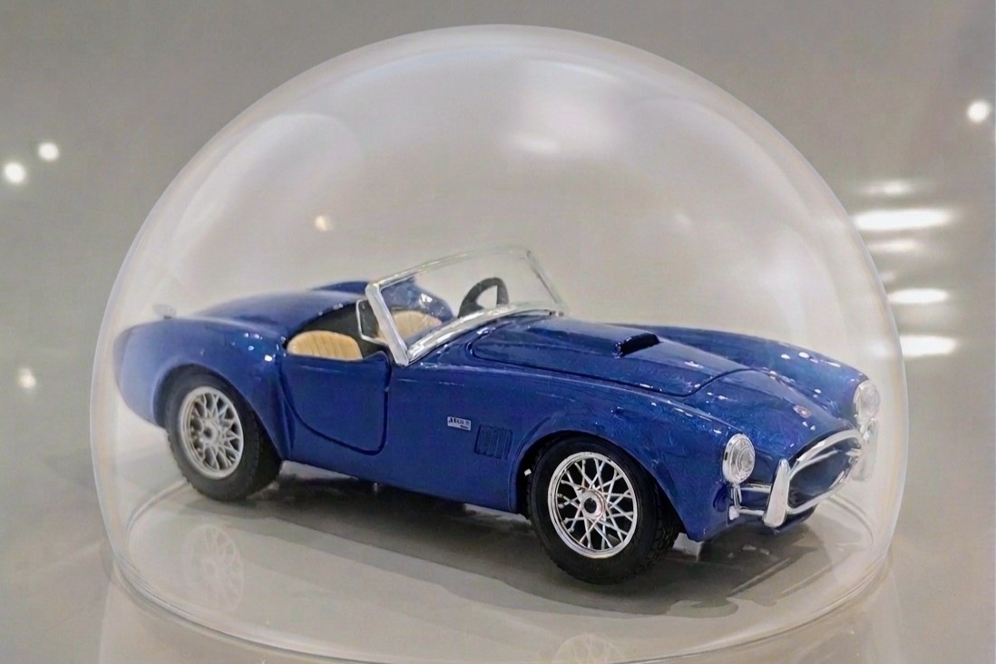 Klassisches Modellauto unter einer Glashaube – Symbol für Oldtimer und Werterhalt